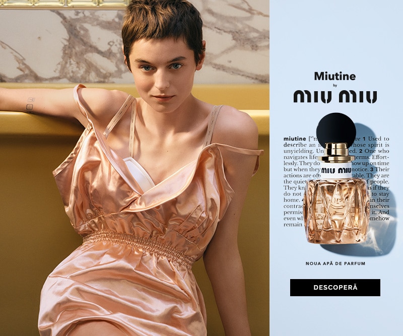 Model purtând o rochie satinată roz lângă afișul parfumului Miutine by Miu Miu, prezentând sticla elegantă de eau de parfum.